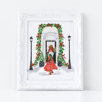 Framed artwork of a woman in a red dress standing in front of a decorated archway with Christmas wreaths.